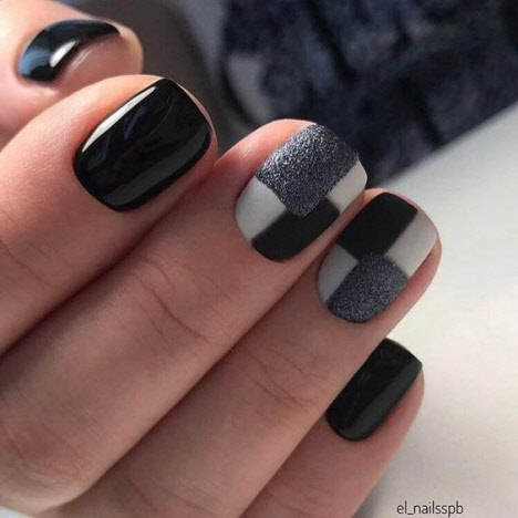 Manicura en colores oscuros para uñas cortas.