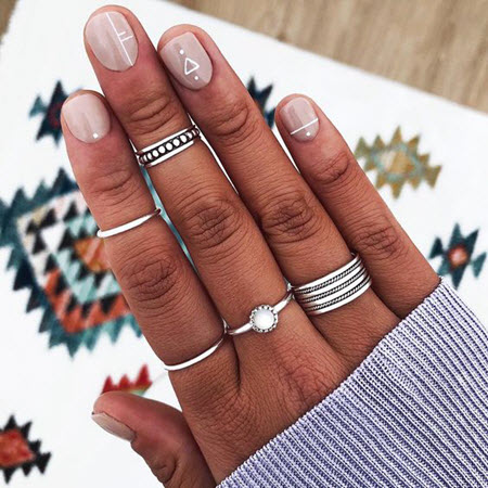 Diseño de manicura geométrica para uñas muy cortas.